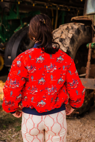 Rear fit of the Southern Cowboy Bomber Jacket by Turquoise Haven, showing full sleeves and a gathered navy hem over cream pants.