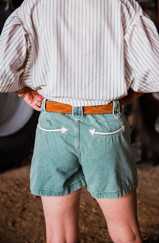 toast suede Western leather belt by double j saddlery with white figure 8 gunslinger stitching styled with teal shorts by howdy hanny