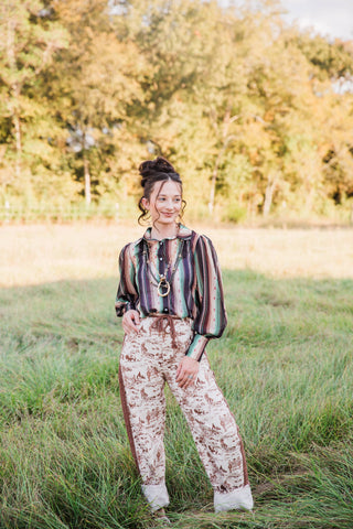 Full-length outfit with the Turquoise Haven Sagebrush Trails Serape Blouse, long gathered sleeves and cream printed jeans.