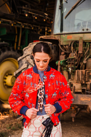 Southern Cowboy Bomber Jacket by Turquoise Haven with red quilted fabric, cowboy print and navy ribbed collar and cuffs.