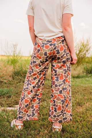 Back view of Varsity Rodeo Duck Camo Lace Trim Pants showing the wide-leg shape and allover rust, olive, tan, and dark camo print.