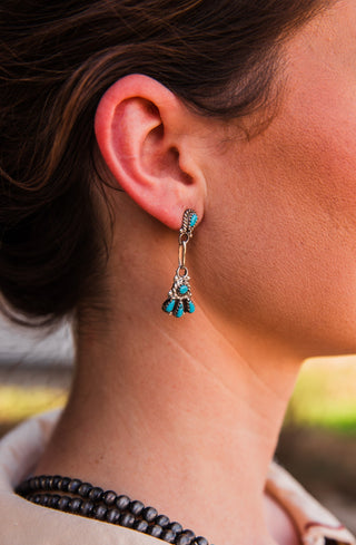 Close-up of the Whisper Dangle Earring in sterling silver, with turquoise stones, a long link and a fan-shaped drop.