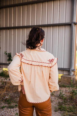 Back view of the cream Winchester Top, showing a burgundy embroidered ruffle yoke, gathered fabric and scalloped hem.