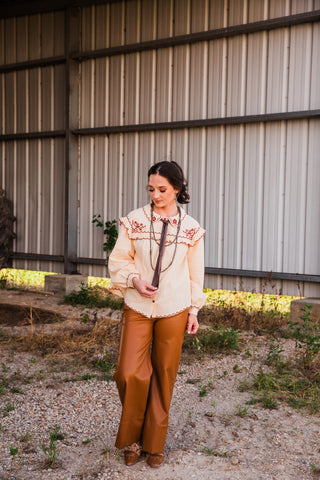 Full-length front view of the cream Winchester Top, showing its embroidered shoulder yoke, long sleeves and scalloped hem.