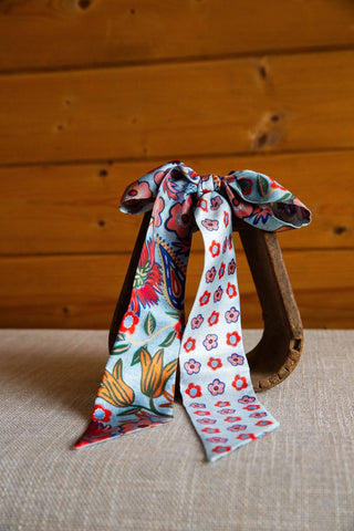 Cottage Garden silk twilly by XOXO Art & Co, close view of orange tulips, pink and red flowers, and green leaves on soft blue.